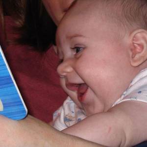 bebelus care se uita la o carte cu povesti (www.babytalk.org)
